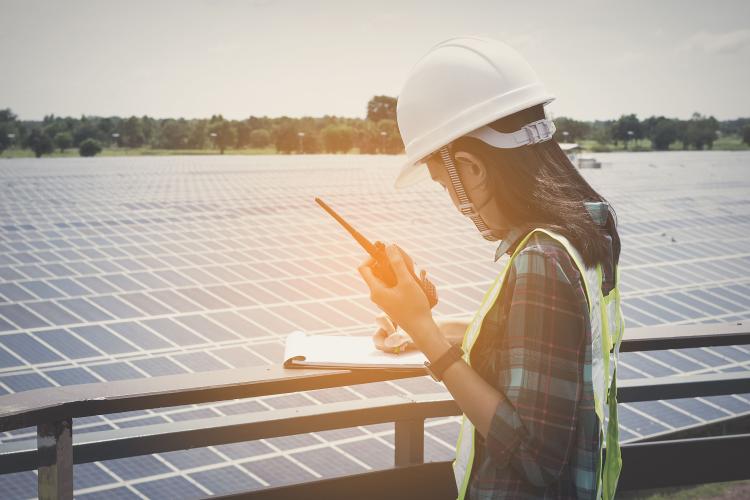 Woman reporting solar panel data. Photo by shutterstock